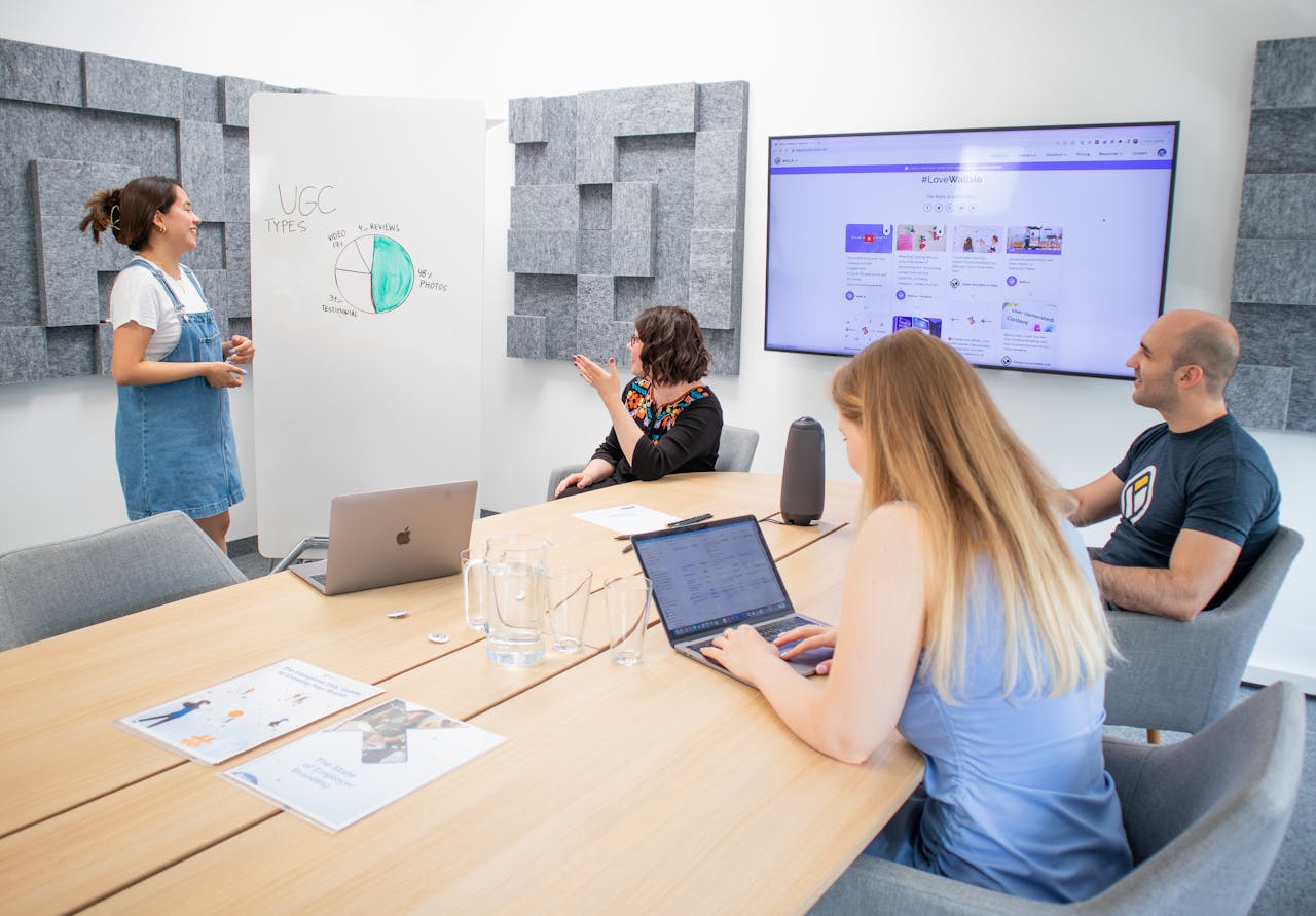 Team collaborating in a modern office with presentations and laptops, focusing on marketing strategies.